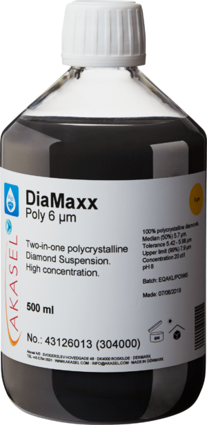 Akasel DiaMaxx Poly 6 µm: A 500 ml plastic bottle with a white screw cap, filled with a black polycrystalline diamond suspension. The label shows the product name “DiaMaxx Poly 6 µm” along with the description “Two-in-one polycrystalline Diamond Suspension. High concentration.” Additional information includes: “100% polycrystalline diamonds,” “Median (50%) 5.7 µm,” “Tolerance 5.42 – 5.98 µm,” “Upper limit (99%) 7.9 µm,” and a concentration of “20 ct/l.” Symbols on the label provide instructions on storage and shelf life.