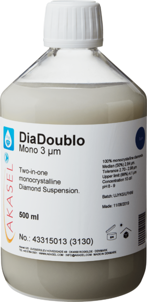 Akasel DiaDoublo Mono 3 µm: A 500 ml plastic bottle with a white screw cap, filled with a light, milky-white monocrystalline diamond suspension. The label shows the product name “DiaDoublo Mono 3 µm” along with the description “Two-in-one monocrystalline Diamond Suspension.” Additional information includes: “100% monocrystalline diamonds,” “Median (50%) 2.84 µm,” “Tolerance 2.7 – 2.98 µm,” “Upper limit (99%) 4.1 µm,” a concentration of “10 ct/l,” and a pH value of “8 – 9.” Symbols on the label indicate storage instructions and shelf life.
