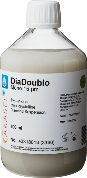 Akasel DiaDoublo Mono 15 µm: A 500 ml plastic bottle with a white screw cap, filled with a light, milky-white monocrystalline diamond suspension, described as a 2-in-1 diamond suspension. The label shows the name “DiaDoublo Mono 15 µm” along with the text “Two-in-one monocrystalline Diamond Suspension.” Additional visible information includes: “100% monocrystalline diamonds,” “Median (50%) 15 µm,” “Tolerance 14.2 – 15.8 µm,” “Upper limit (99%) 21.5 µm,” and “Concentration 10 ct/l.” Symbols on the label provide instructions on storage, shelf life, as well as batch and production information.