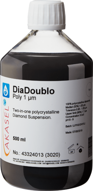 Akasel DiaDoublo Poly 1 µm: A 500 ml plastic bottle with a white screw cap, filled with a black 2-in-1 polycrystalline diamond suspension. The label shows the product name “DiaDoublo Poly 1 µm” along with the description “Two-in-one polycrystalline Diamond Suspension.” Additional details include: “100% polycrystalline diamonds,” “Median (50%) 1.00 µm,” “Tolerance 0.95 – 1.05 µm,” “Upper limit (99%) 1.7 µm,” with a concentration of 10 ct/l and a pH value of 8–9. Symbols indicate storage requirements, along with a batch number and a manufacturing date.