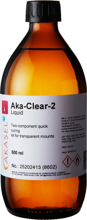 Akasel Aka-Clear-2 Liquid, 500 ml: Brown glass bottle with a yellow cap containing liquid for a two-component acrylic system. The label features the product name, Article No. 25202413 (8602), along with information on quick curing and specific usage instructions. Specifically designed for metallographic applications, ideal for creating transparent mounts in combination with Aka-Clear-2 Powder for precise analysis and sample preparation.