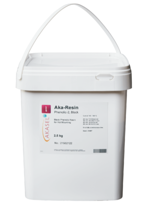 Akasel Aka-Resin Phenolic-2, noir : Résine phénolique noire dans un récipient en plastique blanc avec une poignée de transport. L'étiquette indique le nom du produit, "Résine phénolique noire pour montage à chaud", le poids de 2,5 kg, le numéro d'article 21502122, et les instructions de durcissement telles que : 160-180 °C à 25 mm : 7,5 kN, 6,5 minutes, ainsi que des spécifications supplémentaires de force et de temps pour différents diamètres d'échantillons.